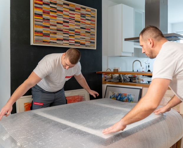 Wiener Möbelpacker Team verpackt Gegenstände mit Verpackungsmaterial